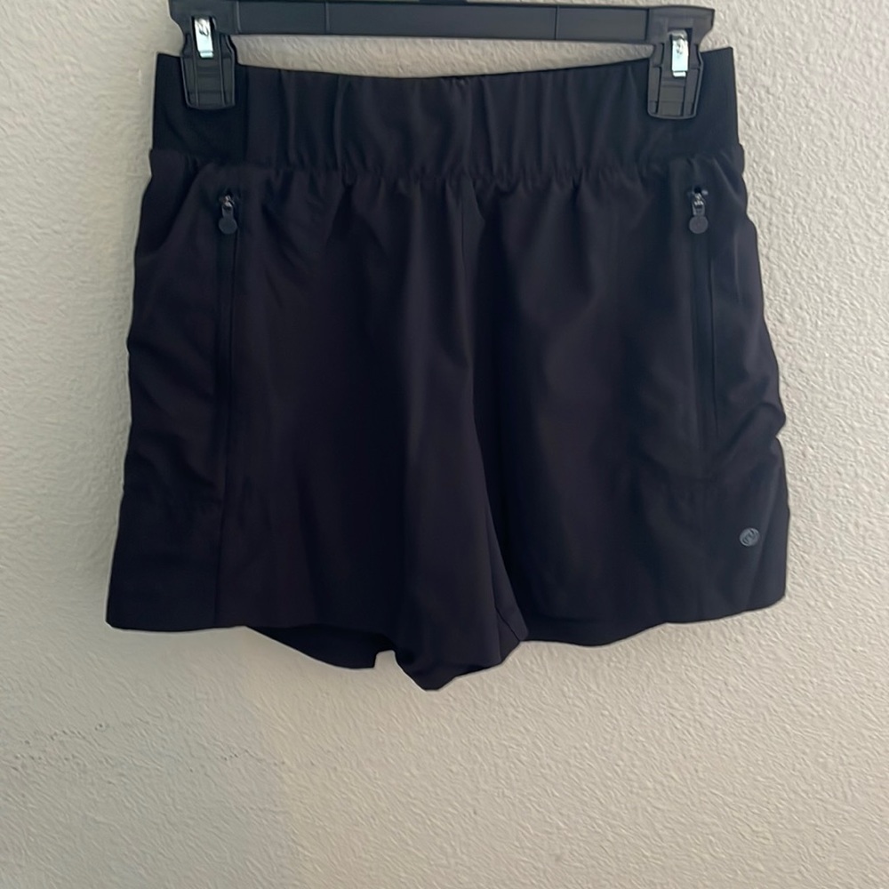 black shorts, mid-thigh length. pockets on both sides